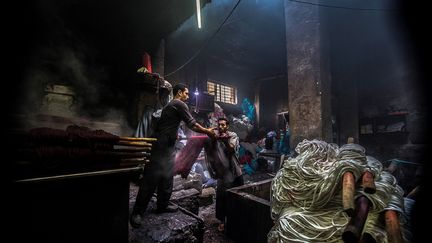 Ses deux fils, Samir Salama, 40 ans, et Mohamed Kamel, 36 ans, travaillent avec lui depuis des années pour perpétuer cette tradition et sauvegarder les pratiques de ce lieu ouvert en 1901.&nbsp; &nbsp; (KHALED DESOUKI / AFP)