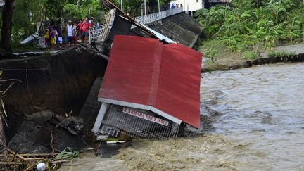 Des villageois constatent l'effondrement de leur salle communale, &agrave; Janiuay, dans la province d'Iloilo. ( REUTERS)