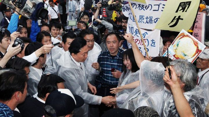 L'ancien Premier ministre Yukio Hatoyama sert la main d'un&nbsp;anti-nucl&eacute;aire pendant une manifestation organis&eacute;e devant la r&eacute;sidence du Premier ministre, occup&eacute;e par&nbsp;Koshihiko Noda, le 20 juillet 2012.&nbsp; (JIJI PRESS / AFP)