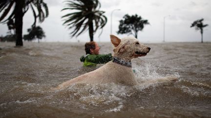 Un habitant de La Nouvelle-Orl&eacute;ans&nbsp;(Louisiane) et son chien s'amusent dans les eaux en crue du lac Pontchatrain &agrave; l'approche de l'ouragan Isaac, le 28 ao&ucirc;t 2012. (CHRIS GRAYTHEN / GETTY IMAGES / AFP)