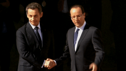 François Hollande et Nicolas Sarkozy se serre la main, devant le palais de l'Elysée, le 15 mai 2012. (FTV)