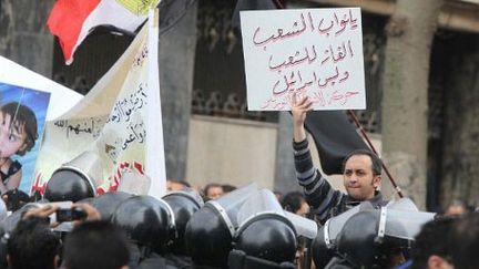 Au Caire, le 23 janvier 2012: devant le parlement, un homme dénonce sur une pancarte le contrat gazier avec Israël: «Le gaz doit revenir aux Egyptiens pas à Israël.» (AFP PHOTO/KHALED DESOUKI)