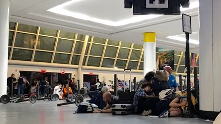 Des passagers&nbsp;se couchent sur le sol pendant une fausse alerte à l'aéroport JFK de New York (Etats-Unis), dimanche 14 août 2016. (BRIGITTE DUSSEAU / AFP)