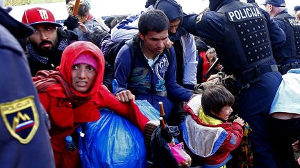 Les migrants r&eacute;agissent alors que la police s'est servi d"un spray poivr&eacute; pour disperser la foule tentant de briser le cordon de police pr&egrave;s de la fronti&egrave;re autrichienne &agrave; Sentij, en Slov&eacute;nie, le 20 octobre 2015. (? LEONHARD FOEGER / REUTERS)