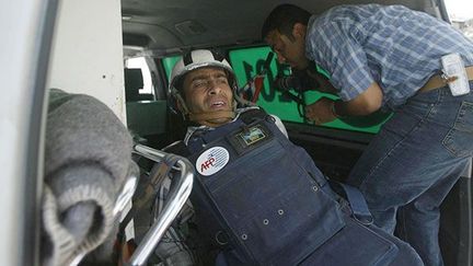 un photographe palestinien de l'AFP, légèrement blessé aux jambes par des tirs de soldats israéliens, est transporté vers un hôpital de Deir Al-Balah, ville du centre de la bande de Gaza, le 5 mai 2004. Les militaires dispersaient des jeunes lanceurs de pierres.

Souheib Jadallah, de l'agence Reuters, a lui aussi été touché.

Les tirs se sont produits alors que les deux hommes prenaient les jeunes en photo. (AFP PHOTO/STR)