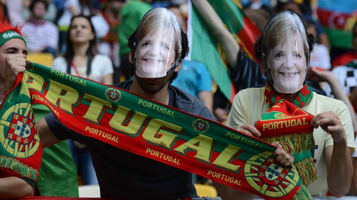 Des supporters portugais portant des masques &agrave; l'effigie de la chanceli&egrave;re allemande Angela Merkel, le 13 juin 2012.&nbsp; (JEFF PACHOUD / AFP)