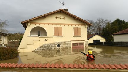 Un pompier inspecte un quartier inondé de Peyrehorade (Landes) le 14 décembre 2019. (GAIZKA IROZ / AFP)