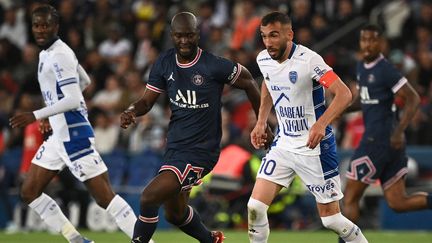 Danilo et Tardieu au contact lors de PSG-Troyes, au Parc des Princes, le 8 mai 2022. (ANNE-CHRISTINE POUJOULAT / AFP)