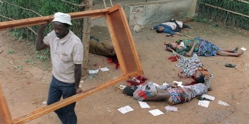 A Kigali, le 11 avril 1994. Un Rwandais récupère un cadre de lit dans une maison dont les habitants ont exécutés. (PASCAL GUYOT / AFP)