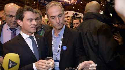 Le Premier Ministre Manuel Valls boit un verre de lait avec Thierry Roquefeuil, le président des éleveurs laitiers au Salon de l'agriculture, lundi 29 février, à Paris. (MIGUEL MEDINA / AFP)