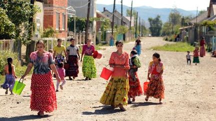 Des femmes de la communauté rom ukrainienne vont chercher de l'eau dans le village de Korolevo en Transcarpatie (ouest) le 7 septembre 2013. La minorité rom en Ukraine comprendrait quelque 400.000 personnes. (AFP - Yuriv Dyachyshyn)