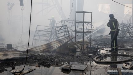 Les pompiers en intervention après qu'une frappe russe a frappé la capitale ukrainienne Kiev, le 29 décembre 2023. (OLEKSII CHUMACHENKO / ANADOLU / AFP)