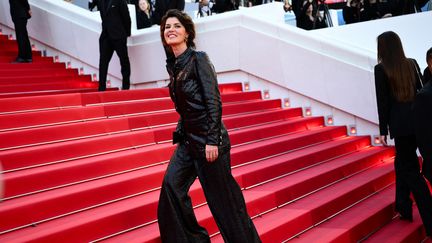 Joyeuse et enthousiaste, Irène Jacob gravit les marches du Palais des Festivals pour la projection de 