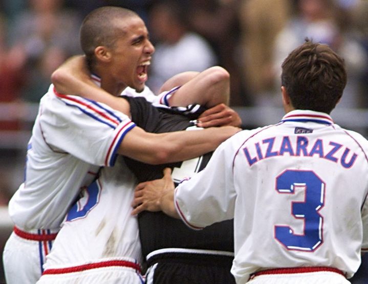 David Trezeguet (left) and Bixente Lizarazu (right) hugging goalkeeper Fabien Barthez (centre) after France qualified for the semi-finals of the World Cup, July 3, 1998. (PEDRO UGARTE / AFP)