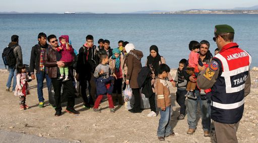 Un gendarme turc prend en charge un groupe de réfugiés à Cesme (ouest de la Turquie) pour les conduire à des bus le 1er décembre 2015. Il s'agit de les empêcher de s'embarquer pour l'île grecque de Chios et de pouvoir ainsi arriver sur le territoire de l'UE. (REUTERS - Denizhan Guzel)