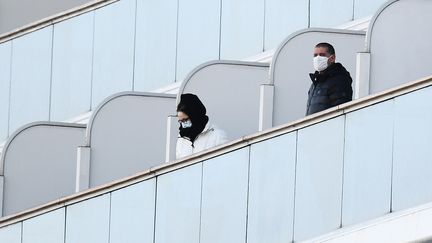 Des passagers sur les balcons du bateau de croisière Diamond Princess placé en quarantaine au large de Yokohama près de Tokyo au Japon, le 10 février 2020 (photo d’illustration). (CHARLY TRIBALLEAU / AFP)