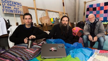 Les trois grévistes de la faim,&nbsp;le prêtre Philippe Demeestere, Anaïs Vogel et son compagnon Ludovic Holbein, le 27 octobre 2021 dans l'église Saint-Pierre de Calais (Pas-de-Calais) (MATHIEU PATTIER / MAXPPP)