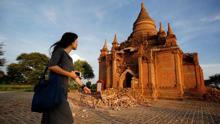 Un séisme de magnitude 6,8 a frappé la Birmanie le 24 août.&nbsp;Quelques 185 pagodes ou monuments bouddhistes ont été endommagés lors du tremblement de terre. Trois morts sont à déplorer. Ici une femme marche devant une pagode partiellement dévastée de Bagan, le lendemain du séisme. (SOE ZEYA TUN / REUTERS / X02594)