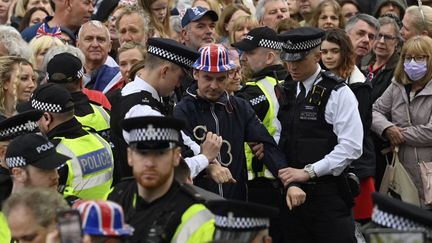 Des manifestants du groupe de protestation climatique "Just Stop Oil" sont appréhendés par des policiers près de l'abbaye de Westminster, dans le centre de Londres, le 6 mai 2023. (JUSTIN TALLIS / AFP)