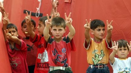 Le 27 juin 2011, pendant que les adultes sont en guerre, les enfants attendent la victoire, celle qui les ramènera au pays. (AFP PHOTO / ADEM ALTAN)