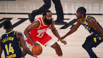 James Harden des Houston Rockets dribble le ballon entre JaKarr Sampson (à g.) et Justin Holiday (à d.) des Indiana Pacers, le 12 août 2020, en Floride.  (POOL / GETTY IMAGES NORTH AMERICA)