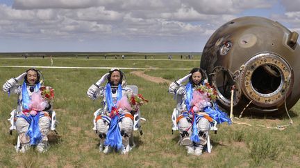 Les trois astronautes chinois saluent apr&egrave;s leur retour sur terre &agrave; bord de la capsule&nbsp;Shenzhou-10 au milieu des steppes mongoliennes (Chine), le 26 juin 2013. (REUTERS)