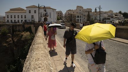 People protect themselves from the sun with umbrellas during a heatwave, in Ronda, southern Spain, on August 9, 2024. (JORGE GUERRERO / AFP)