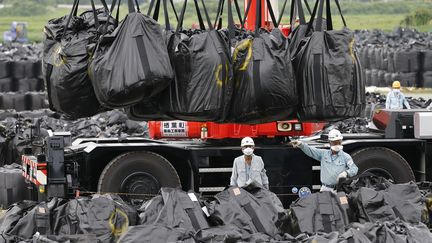 Des employ&eacute;s continuent les op&eacute;rations de nettoyage et de d&eacute;contamination, &agrave; Naraha, &agrave; 20 km de la centrale, le 24 ao&ucirc;t 2013. (ISSEI KATO / REUTERS)