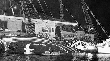 Le Rainbow Warrior couché sur le côté dans le port d'Auckland, le 10 juillet 1985. (AFP / New Zealand Herald)