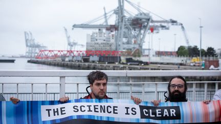 Des militants d'Extinction Rebellion lors d'une action de blocage au Havre (Seine-Maritime), le 12 mai 2023, contre la création d'un terminal méthanier flottant par Total Energie. (EDOUARD MONFRAIS-ALBERTINI / HANS LUCAS / AFP)