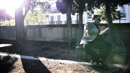 L'écrivain égyptien Alaa el Aswany sur un banc des jardins de l'institut "Imera" de l'Université d'Aix-Marseile. (ANNE-CHRISTINE POUJOULAT / AFP)