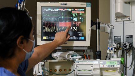 Une soignante s'occupe d'un patient au service de réanimation de l'hôpital Avicenne de l'AP-HP à Bobigny, près de Paris, le 8 février 2021. (BERTRAND GUAY / AFP)