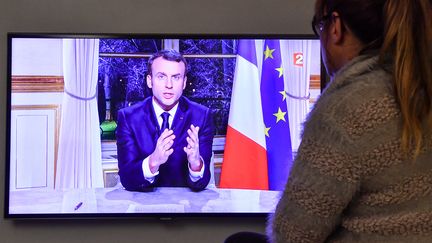 Une femme regarde les vœux&nbsp;d'Emmanuel Macron à la télévision,&nbsp;le 31 décembre 2017. (PHILIPPE HUGUEN / AFP)