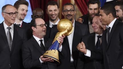 Les conseils musculation de Daniel Narcisse &agrave; Fran&ccedil;ois Hollande, pour soulever le troph&eacute;e de pr&egrave;s de 40 kg gagn&eacute; au Qatar. (ERIC FEFERBERG / AFP)