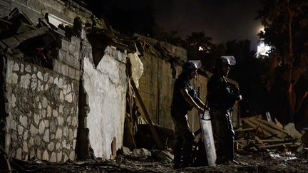 Deux gendarmes surveillent le quartier démoli de Talus 2 lors de l'opération Wuambushu à Mayotte, le 25 mai 2023 (PHILIPPE LOPEZ / AFP)