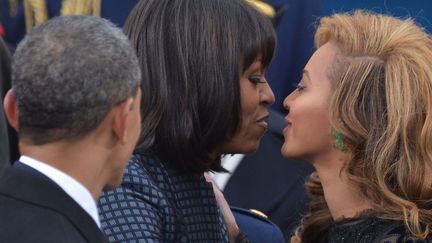 La First Lady Michelle Obama (C) f&eacute;licite la chanteuse Beyonc&eacute;&nbsp;(D) lors de la c&eacute;r&eacute;monie d'investiture du pr&eacute;sident am&eacute;ricain Barack Obama (G), Washington (Etats-Unis), le 21 janvier 2013. (JEWEL SAMAD / AFP)