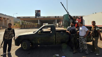 Des rebelles syriens posent le 20 juillet 2012 devant le poste-fronti&egrave;re syrien de Bab al-Haoua, &agrave; la fronti&egrave;re avec la Turquie, apr&egrave;s en avoir pris le contr&ocirc;le. (BULENT KILIC / AFP)