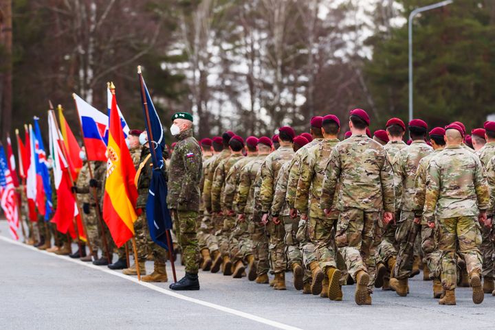 Passage en revue des soldats de la&nbsp;base militaire de l'Otan, à Adazi (Lettonie), le 25 février 2022. (GINTS IVUSKANS / AFP)