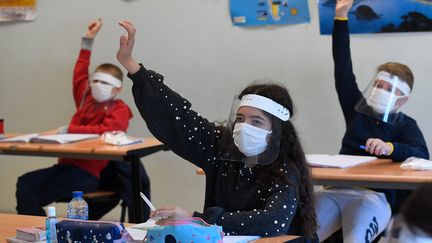 Des élèves masqués pour éviter d'être contaminé par le coronavirus, le 18 mai 2020 à Saint-Grégoire (Ille-et-Vilaine). (DAMIEN MEYER / AFP)