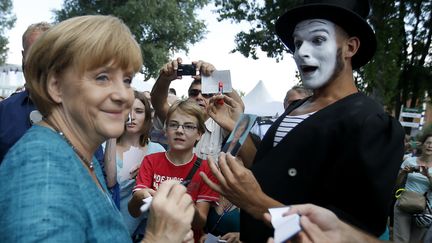 La chanceli&egrave;re allemande, Angela Merkel, signe des autographes pendant une journ&eacute;e portes ouvertes du gouvernement, &agrave; Berlin (Allemagne), le 25 ao&ucirc;t 2013. (FABRIZIO BENSCH / REUTERS)