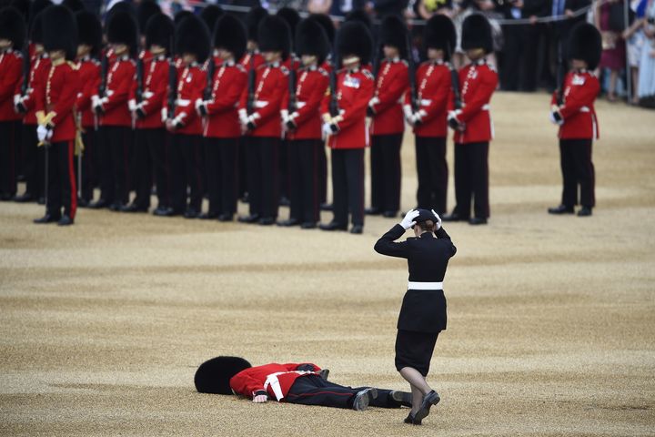 Une collègue officier accourt pour porter assistance à un garde évanoui, le 11 juin 2016, à Londres (Angleterre).&nbsp; (DYLAN MARTINEZ / REUTERS)