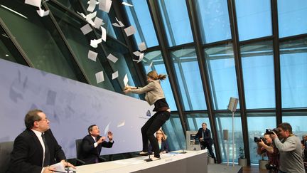 Une femme interrompt Mario Draghi, le pr&eacute;sident de la Banque centrale europ&eacute;enne, au si&egrave;ge de la BCE &agrave; Francfort (Allemagne), le 15 avril 2015 (DANIEL ROLAND / AFP)