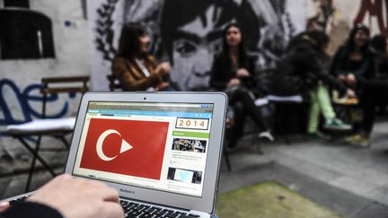 Un Turc devant un écran d'ordinateur, le 27 mars 2014, devant le portrait d'un adolescent mort lors d'une manifestation à Istanbul (Turquie), l'année précédente. (OZAN KOSE / AFP)