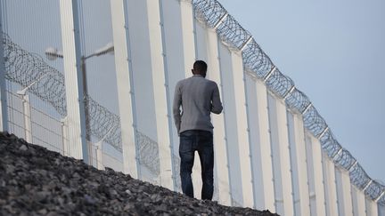 Un r&eacute;fugi&eacute; le long des barbel&eacute;s qui entourent le tunnel sous la Manche, le 25 octobre 2015 &agrave; Calais (Pas-de-Calais). (MUSTAFA YALCIN / ANADOLU AGENCY / AFP)