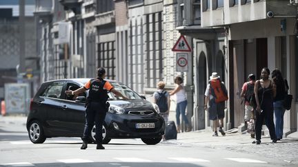 Un policier redirige les voitures après qu'une fusillade a éclaté à Liège (Belgique) faisant quatre morts dont deux policiers et l'assaillant, le 29 mai 2018. (JOHN THYS / AFP)