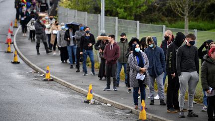 Des dizaines de personnes patientent devant un centre temporaire de vaccination ouvert à Bolton, dans&nbsp;le nord-ouest de l'Angleterre, le 17 mai 2021. (OLI SCARFF / AFP)