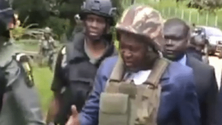 Le gouverneur de la région anglophone du Sud-Ouest, Bernard Okalia Belai, se déplace avec un gilet pare-balles. Il a échappé à une attaque rebelle qui a visé son convoi le 20 avril 2018. (Capture d&#039;écran/DR)