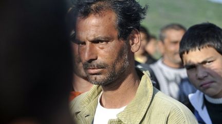 Un homme rom regarde les femmes et les enfants de sa communauté quitter le village de Gyöngyöspata (AFP - ATTILA KISBENEDEK)