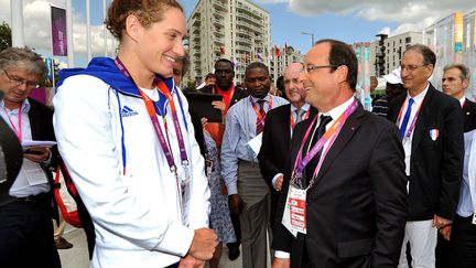 Le pr&eacute;sident Fran&ccedil;ois Hollande avec la championne olympique de 400 m nage libre, Camille Muffat. (JOHN STILLWELL / SIPA)