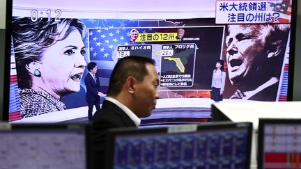 Un employé de la Bourse japonaise regarde la soirée électorale américaine, le 9 novembre 2016, à Tokyo (Japon). (BEHROUZ MEHRI / AFP)